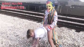 Payaso folla chica en las vías del tren